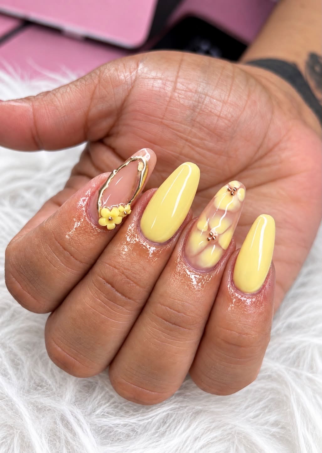 Uñas amarillas con flores en relieve